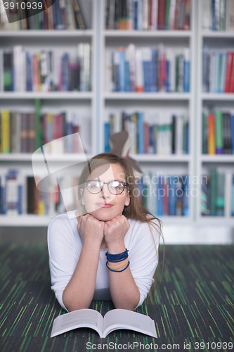 Image of female student study in library, using tablet and searching for 