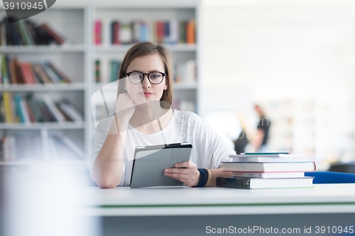 Image of female student study in school library, using tablet