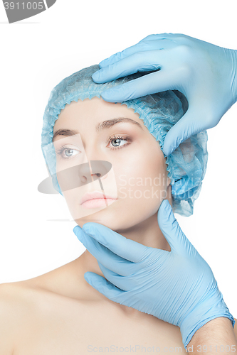 Image of Plastic surgery concept. Doctor hands in gloves touching woman face