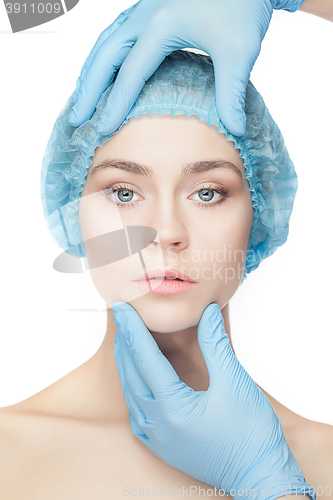 Image of Plastic surgery concept. Doctor hands in gloves touching woman face