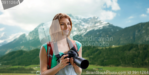 Image of woman with backpack and camera over mountains