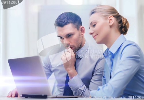 Image of serious business couple with laptop computer