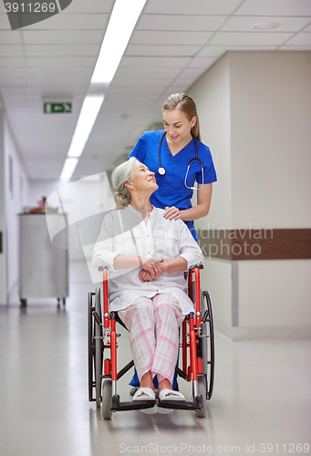 Image of nurse with senior woman in wheelchair at hospital