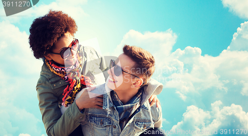 Image of happy teenage couple in shades having fun outdoors