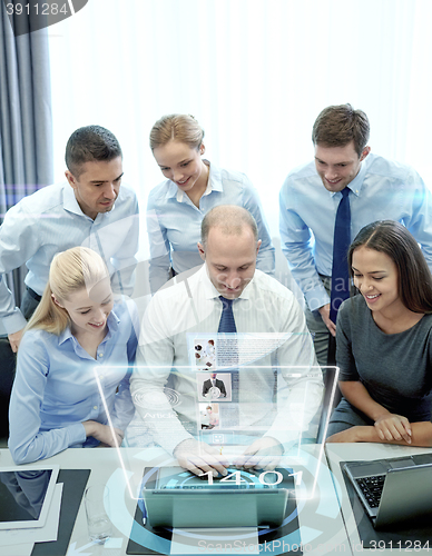 Image of smiling business people with laptop in office