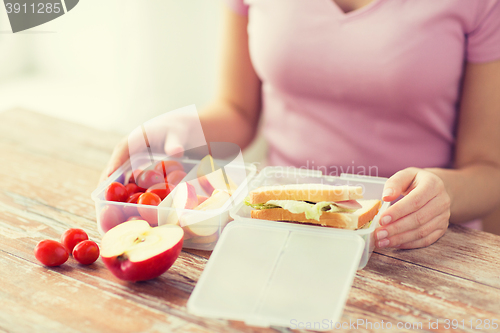 Image of close up of woman with food in plastic container