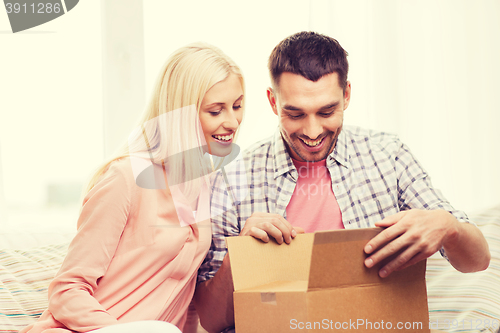 Image of happy couple with parcel box at home