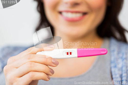 Image of close up of happy woman with home pregnancy test