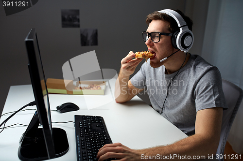 Image of man in headset playing computer video game at home