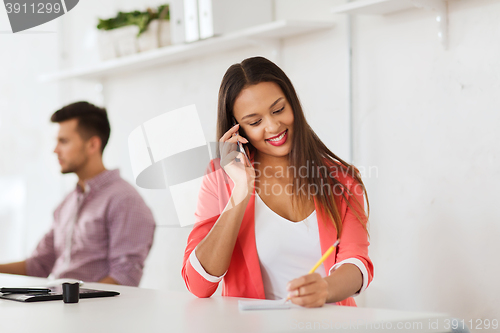 Image of businesswoman calling on smartphone at office