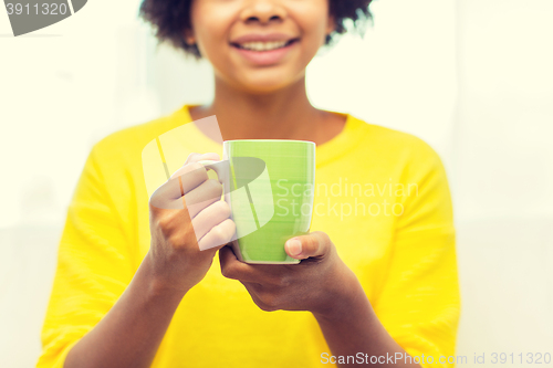 Image of happy african american woman drinking from tea cup