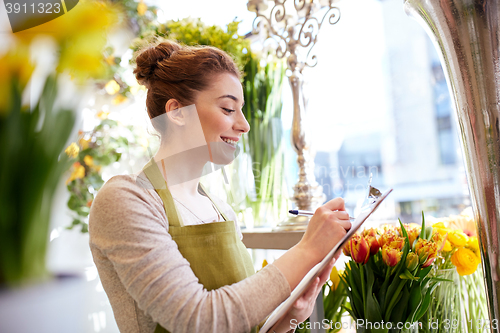 Image of florist woman with clipboard at flower shop