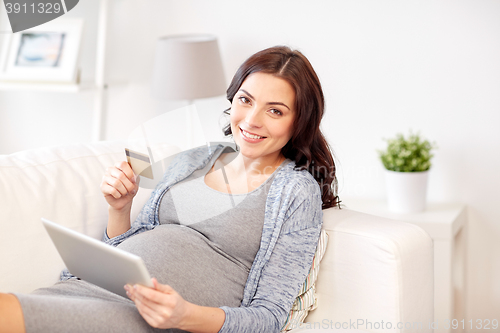 Image of pregnant woman with tablet pc and credit card