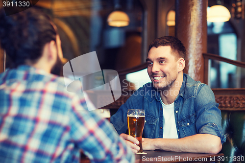 Image of happy male friends drinking beer at bar or pub