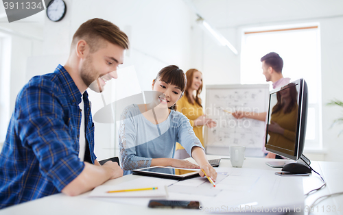 Image of creative team with blueprint at office