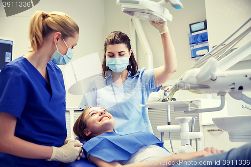 Image of happy female dentist with patient girl at clinic