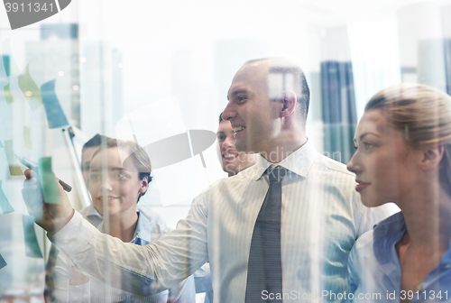 Image of smiling business people with marker and stickers