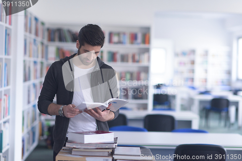 Image of portrait of student while reading book  in school library