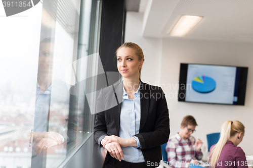 Image of portrait of young business woman at office with team on meeting 