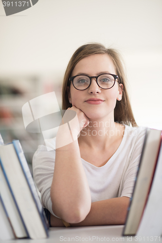 Image of portrait of famale student selecting book to read in library