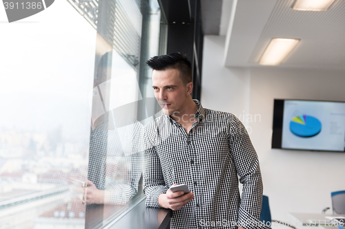 Image of young business man using smart phone at office