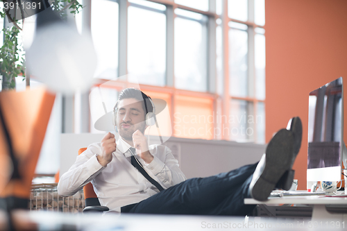 Image of relaxed young business man at office