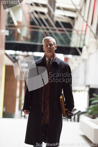 Image of handsome senior business man walking