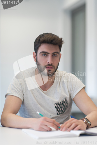 Image of male student taking notes in classroom