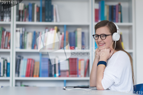 Image of female student study in library, using tablet and searching for 