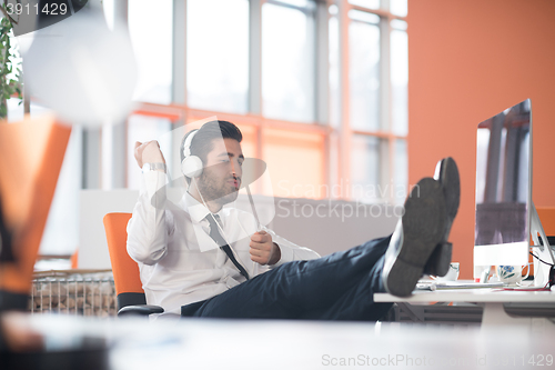 Image of relaxed young business man at office