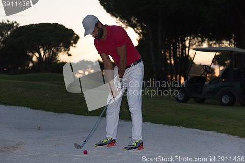 Image of golfer hitting a sand bunker shot on sunset