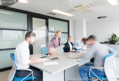 Image of business people group entering meeting room, motion blur