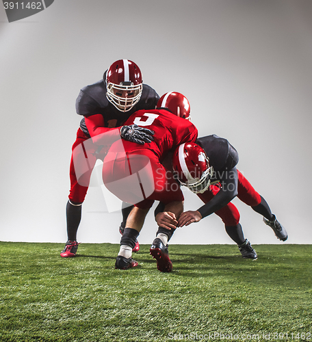 Image of The three american football players in action