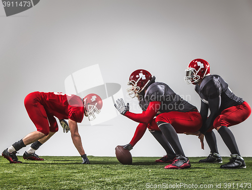 Image of The three american football players in action