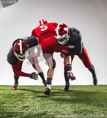 Image of The three american football players in action