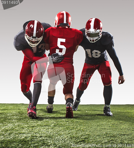 Image of The three american football players in action