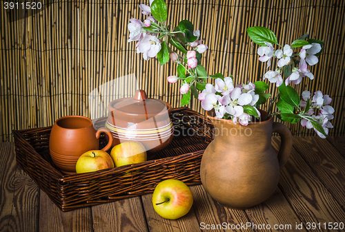 Image of Ripe apple and blossoming branch of an apple-tree in a clay jar,