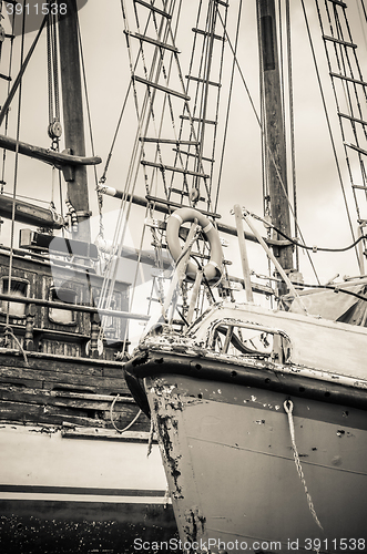 Image of Old collapsing sailboats at the dock, close-up, sepia