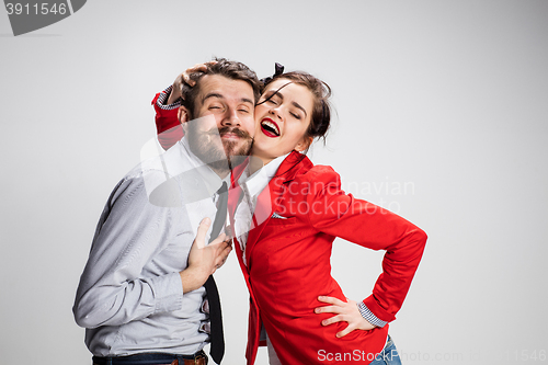 Image of The business man and woman embracing on a gray background