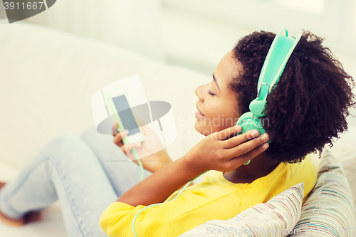 Image of happy african woman with smartphone and headphones