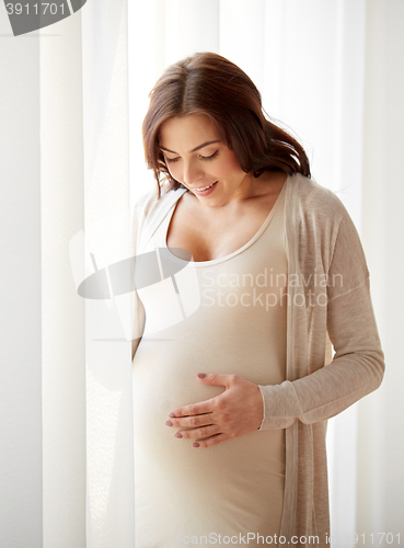 Image of happy pregnant woman with big tummy at home