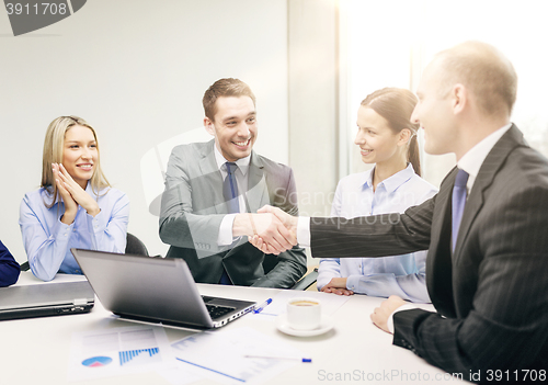 Image of two businessman shaking hands in office