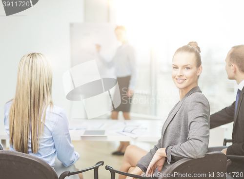 Image of businesswoman with team showing in office