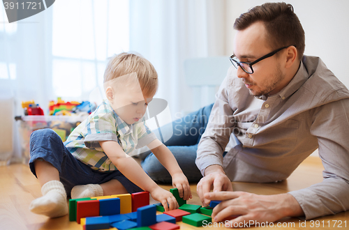 Image of father and son playing with toy blocks at home