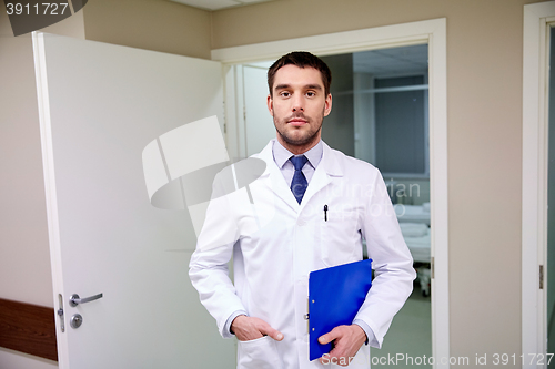 Image of doctor with clipboard at hospital corridor