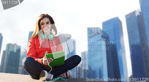 Image of happy young woman with tablet pc and headphones