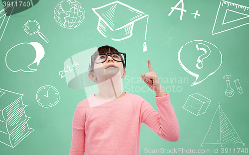 Image of happy little girl in eyeglasses pointing finger up