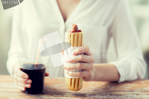 Image of close up of woman with hot dog and coca drink