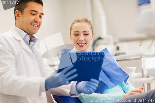 Image of male dentist with tablet pc and woman patient