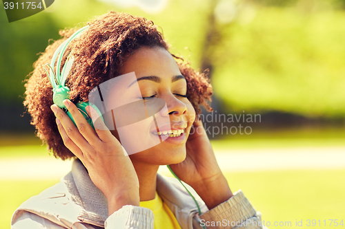 Image of african woman in headphones listening to music